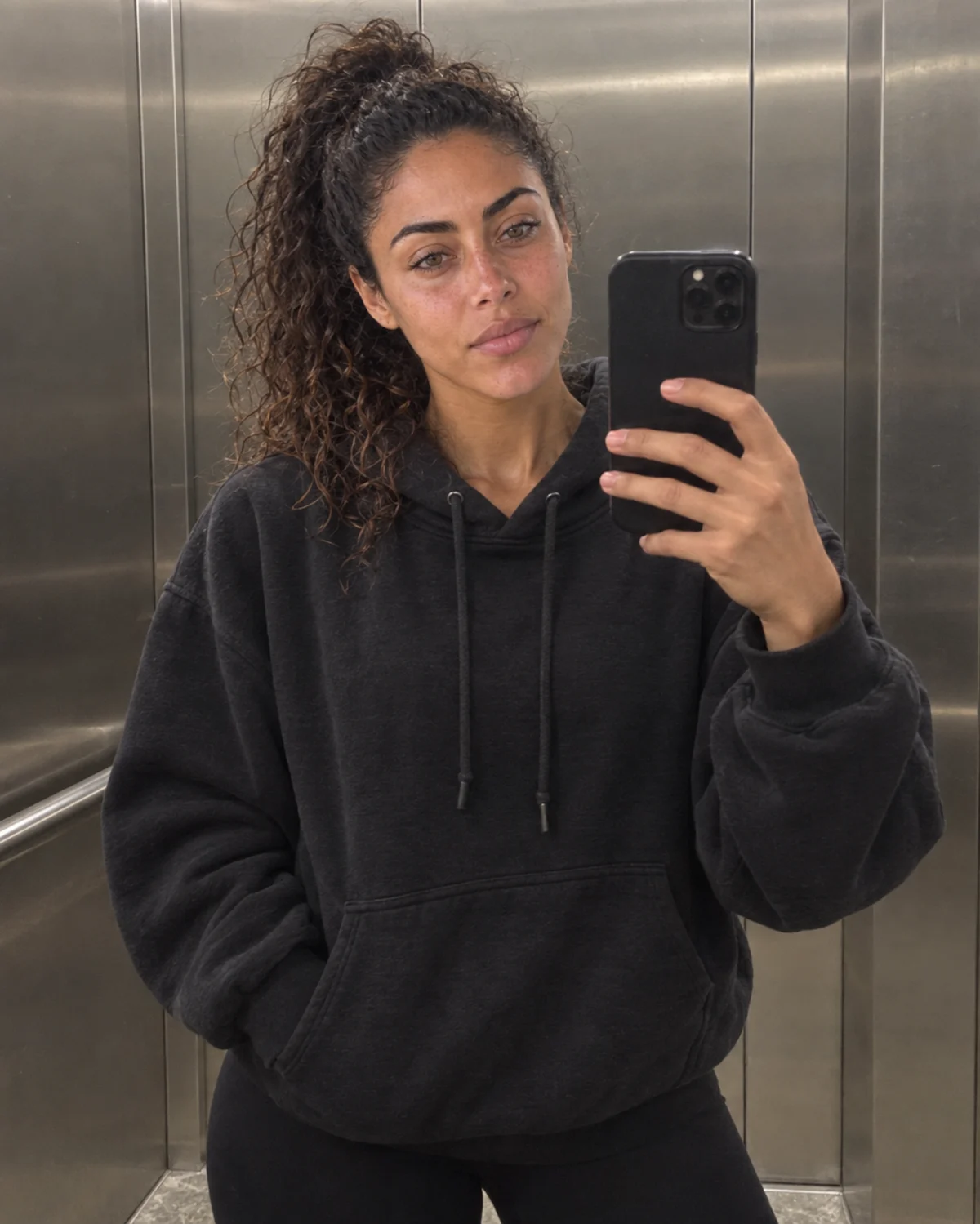 Camila taking an ordinary elevator mirror selfie