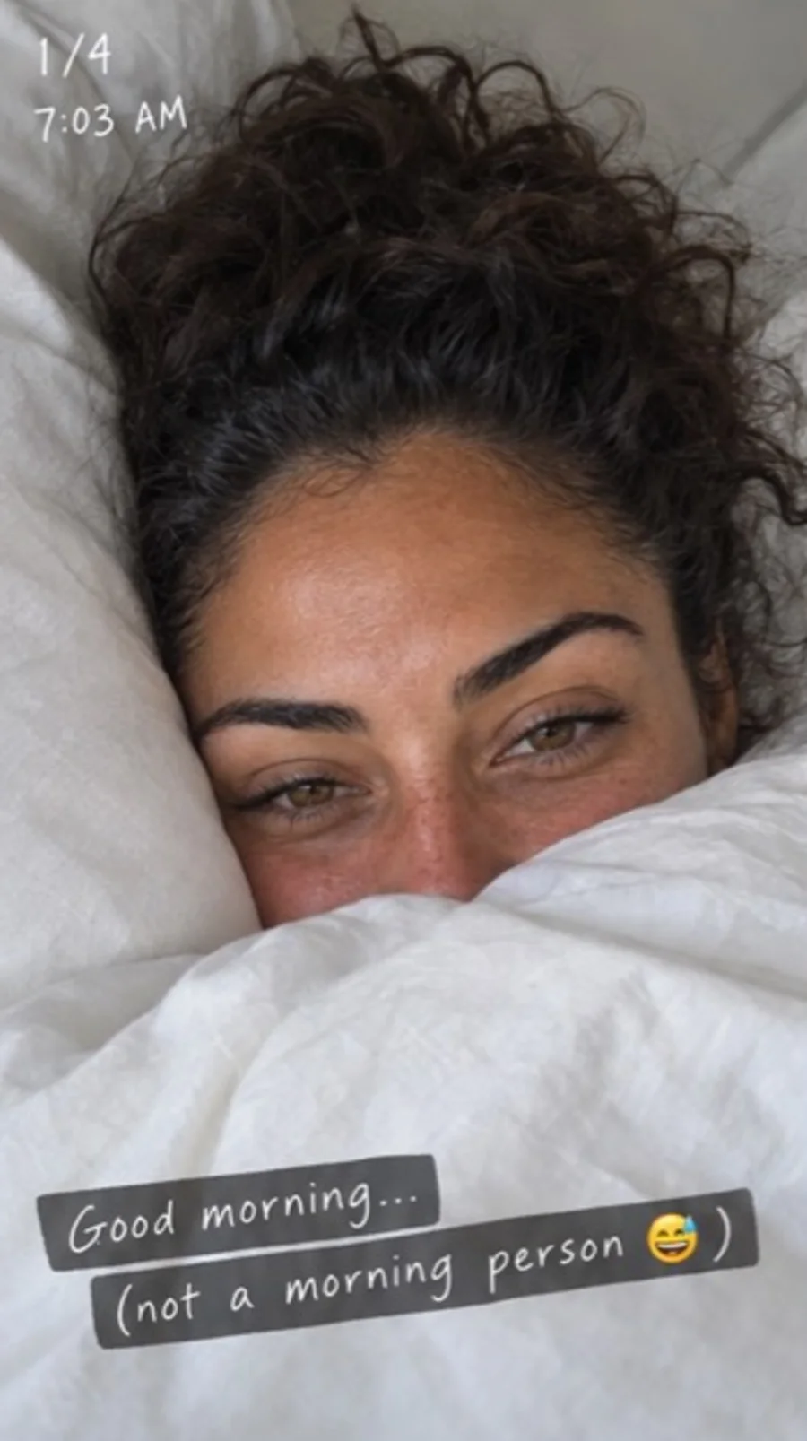 Camila partly hidden under a duvet in an imperfect morning selfie
