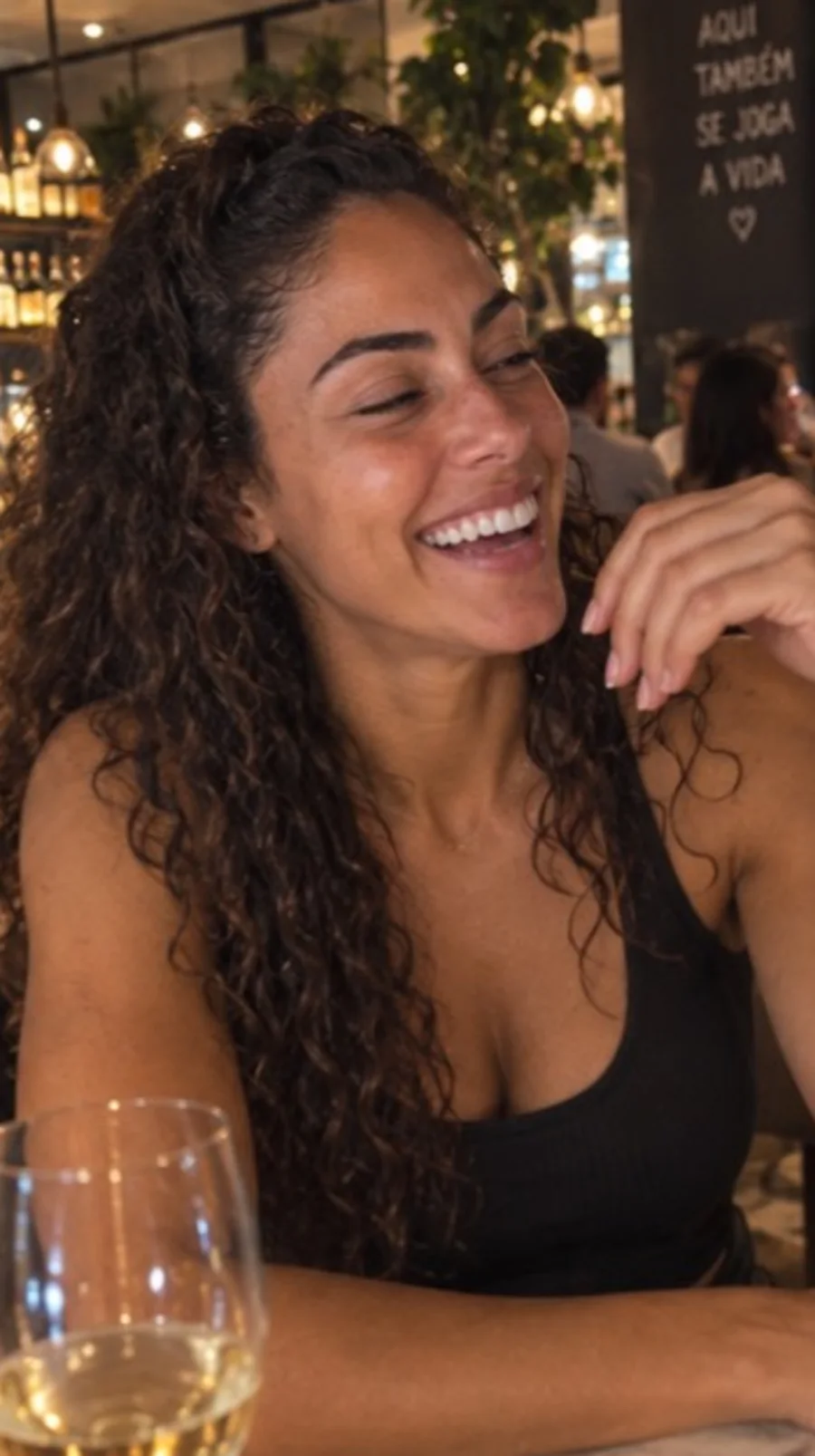 Camila laughing at a restaurant in a friend-shot photo